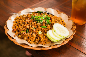 Freshly cooked fried rice on a woven bamboo plate with oil paper lining