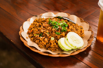 Freshly cooked fried rice on a woven bamboo plate with oil paper lining