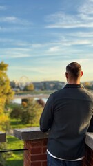 Man is admiring the landcape before the sunset in travel 
Is wearing shirt and the weather is perfect
