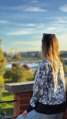 Woman is admiring the landcape before the sunset in travel 
Is wearing shirt sunglasses and the weather is perfect