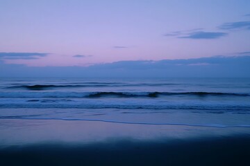 Obraz premium A deep blue ocean at dusk with subtle waves reflecting the fading light, soft breeze stirring the sea air