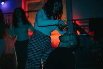 Friends having fun at a house party, engaging in lively interactions and joyful moments under colorful lighting.