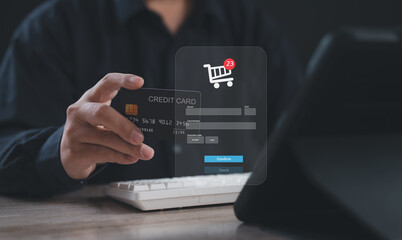 Businessman using a credit card to confirm online purchase through virtual shopping cart interface, representing digital payment, secure transaction, e-commerce, cashless system, and mobile checkout.