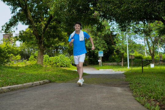 man enjoying a relaxing walk wearing headphones in a green park setting