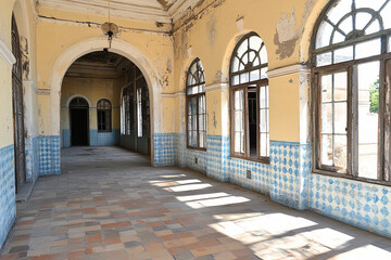 Obraz premium Long empty hallway with faded walls revealing years of neglect and decay in an abandoned building