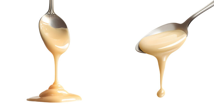 Condensed milk flowing down from a metal spoon isolated on a transparent background