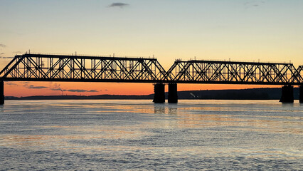 Railway bridge over the river at sunset