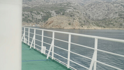 Ferry ship exterior deck white fence with coast in background