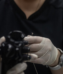 The doctor wears surgical gloves, holds endoscopic biopsychic forceps, preparing to take a biopsy during an endoscopic study, demonstrating experience and focus on healthcare.