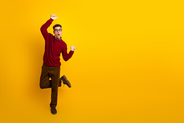 Stylish Young Man in Red Sweater Making an Excited Gesture Against Yellow Background
