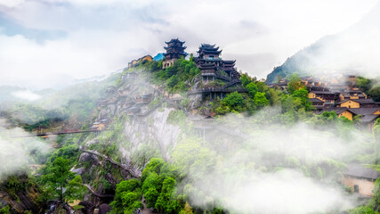 Fototapeta premium Misty Mountain Village with Ancient Structures