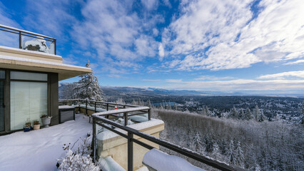Snow on rooftop patio overlooking Fraser Valley, BC, Canada on a sunny winter day.
