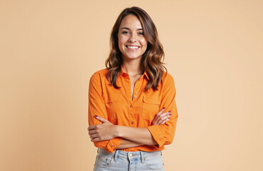 Smiling woman in orange shirt with arms crossed confidently