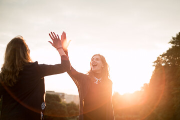 Mother and Daughter High Five at Sunset