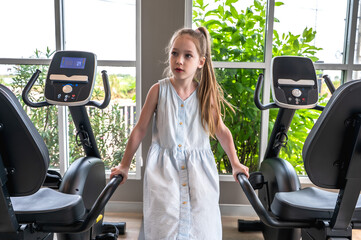 Young Cute Caucasian girl doing exercise in fitness sportclub