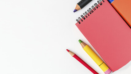 Colorful pencils and notebooks on white desk for creative inspiration