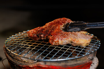 A perfectly grilled beef steak rests on a hot barbecue grill, ready to be served at a lively outdoor party or festive gathering.