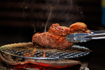 A perfectly grilled beef steak rests on a hot barbecue grill, ready to be served at a lively outdoor party or festive gathering.
