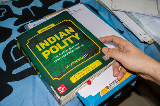 holding Indian Polity book, widely used by aspirants preparing for the UPSC Union Public Service Commission civil services examination in India .