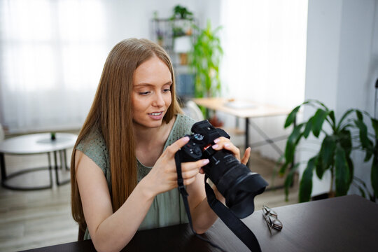 Young woman explores camera settings in cozy indoor setting