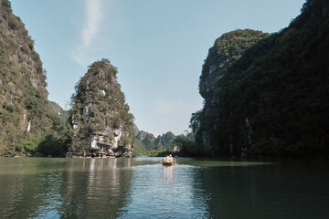 Explore stunning karst formations while rowing in a serene lake in northern Vietnam during a bright day