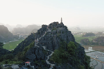Exploring rocky mountains in northern Vietnam with winding paths and lush fields at sunset
