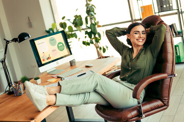 Confident Female Professional Relaxing in Office Workspace with Modern Computer and Bright Indoor...