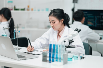 Medical research team conducting scientific experiments in a pharmaceutical laboratory, analyzing...