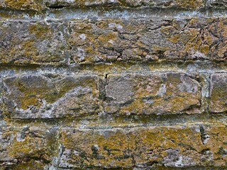 Background of old vintage brick wall, real photo. A closeup shot of a weathered mossy brick wall. Texture, brick, wall, it can be used as a background. Brick texture with scratches and cracks