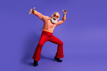 Eccentric elderly man in retro styled disco attire gesturing expressively, posed against a vibrant...