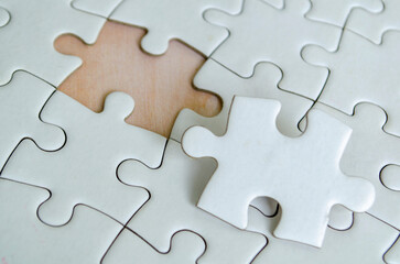 Close up view of interlocking jigsaw puzzle pieces symbolizing problem solving teamwork and...
