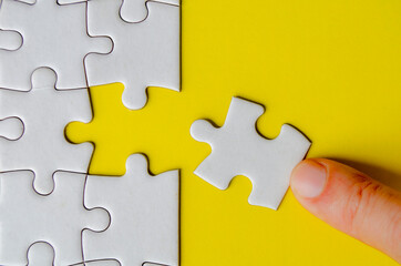 Hand fitting a missing white jigsaw pieces