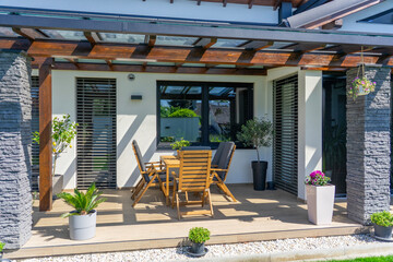 This image showcases a modern residential home with stylish outdoor seating, highlighting the elegant design and inviting atmosphere of the patio space on a sunny day