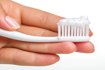 Close-up of a hand holding a toothbrush with white toothpaste, ready for brushing teeth, promoting oral hygiene and dental care, health and wellness routine.