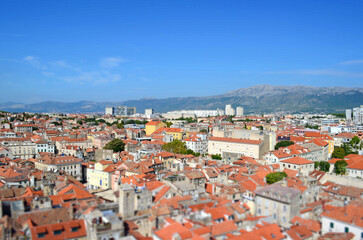 Fototapeta premium Tilt-shift panoramic view of Split old town with red rooftops and Adriatic architecture from church tower