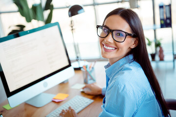 Confident Businesswoman Smiling at Workplace with Natural Light Indoors in Professional Office...