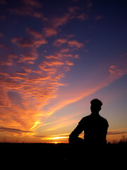 Fototapeta premium Man sitting alone watching the beautiful sunset.