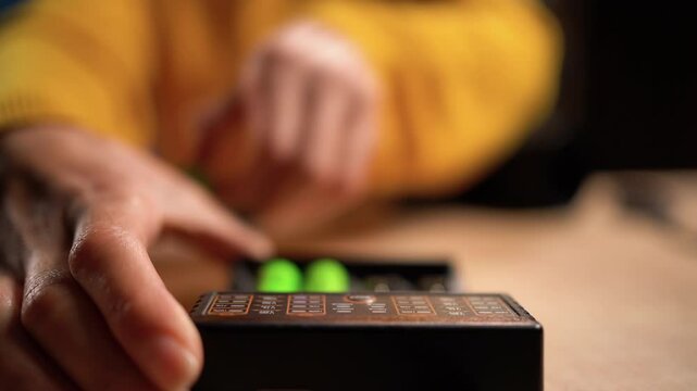 Woman take-out rechargeable batteries from battery charger. Four AA batteries in a charger. Selective focus on hands