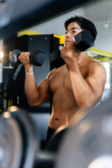 Bodybuilder lifting weights in gym showing muscular physique
