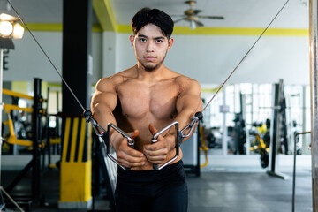 Bodybuilder doing cable crossover exercise in gym