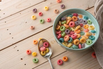 Colorful Cereal Loops with Milk in Bowl. Bowl of vibrant fruit-flavored cereal loops with milk on a wooden surface, ideal for breakfast or playful food themes