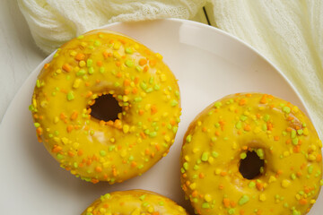 Yellow donuts on a white table. Sweet donuts
