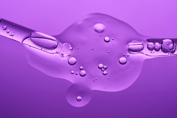 Two pipettes with serum on a lilac background. The texture.