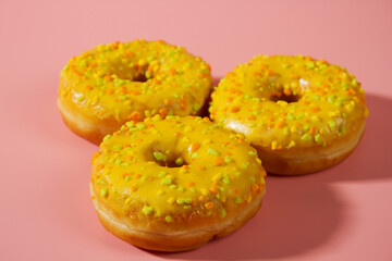 Yellow donuts on a pink background. Sweet donuts