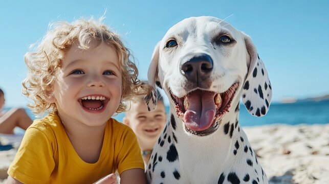 Dalmatian dog smiling with open mouth sits alongside laughing child at beach on sunny day!