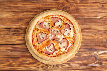 Ham & Mushroom Pizza – A classic pizza topped with juicy ham slices and fresh mushrooms, served on a wooden board over rustic dark wood for a cozy, home-style presentation.