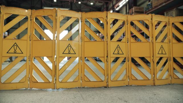 Workers setting up expandable safety barrier in industrial area