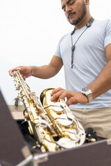 Saxophonist preparing his saxophone on the beach seeking inspiration