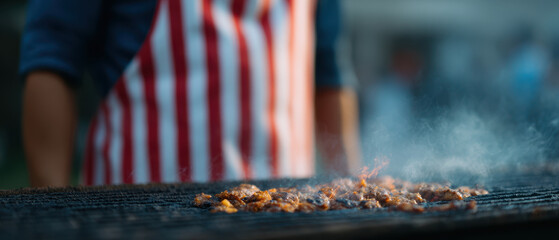 Grilling meat on barbecue with person wearing striped apron