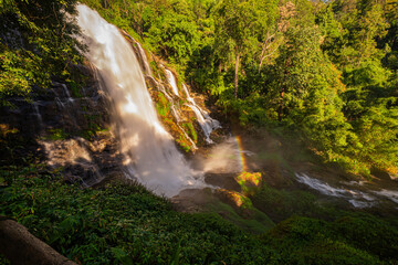 Wachirathan waterfall Chiang Mai is surrounded by lush greenery, with a vibrant rainbow forming in the mist. Water droplets hit by sunlight create rainbows that we can see all day long..